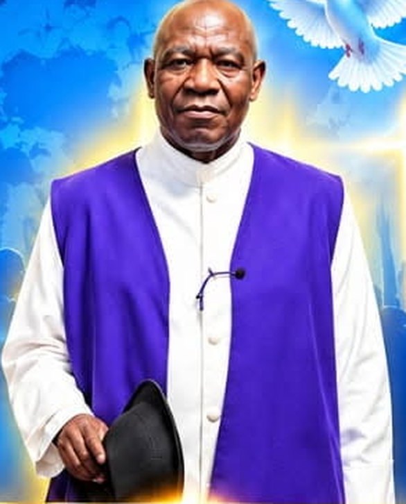 Bishop Maxwell Roberts in a white robe and purple vestment